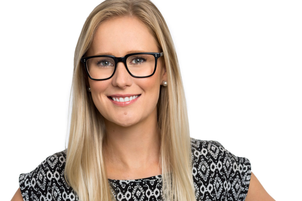 HEadshot of smiling blonde woman with black glasses