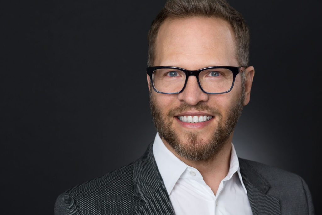 Headshot of smiling man with glasses