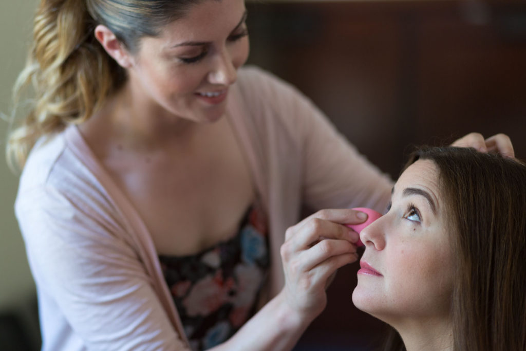 Makeup artist applies makeup before a corporate photo session