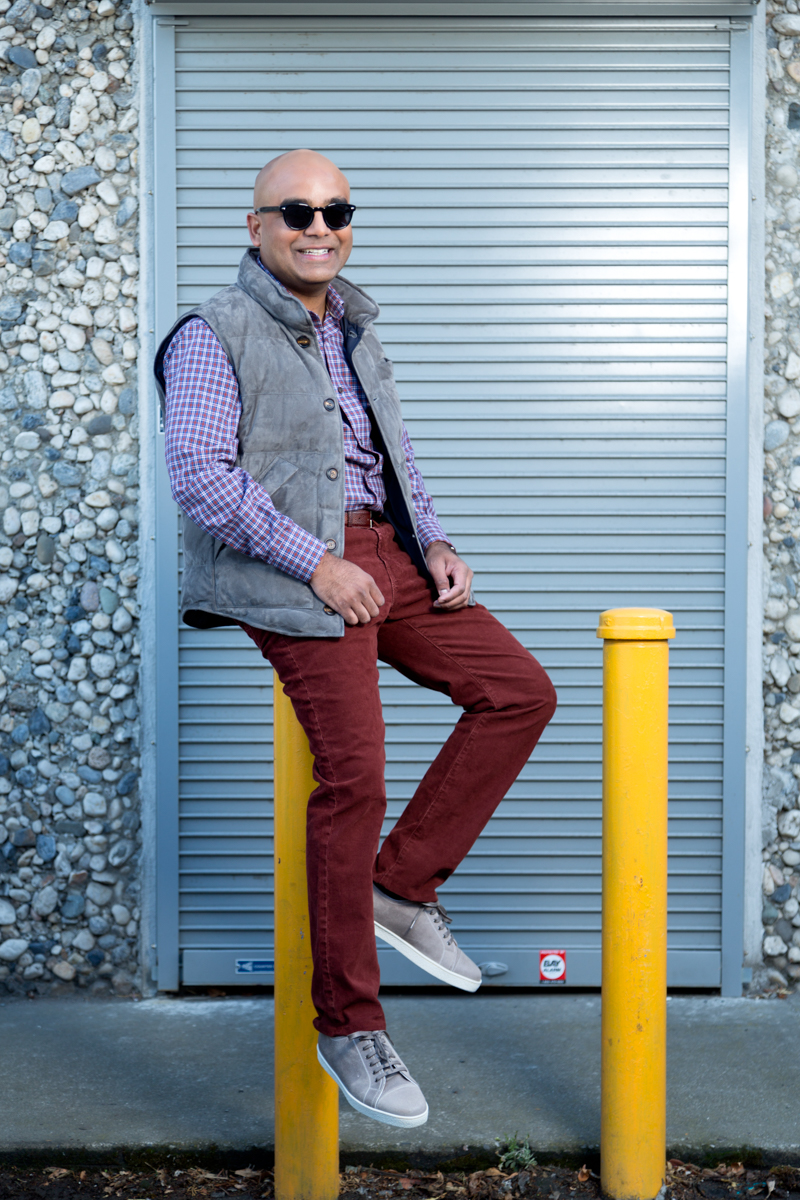 Man in sunglasses sitting on poll in front of garage door