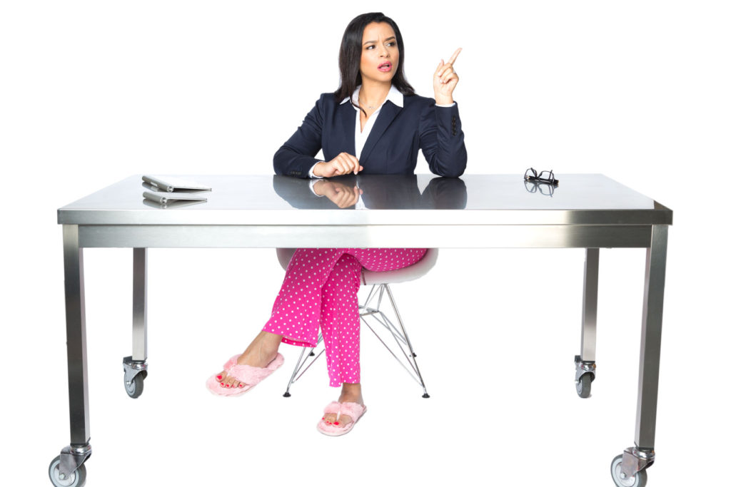 Woman at desk in pajama bottoms and a suit jacket.