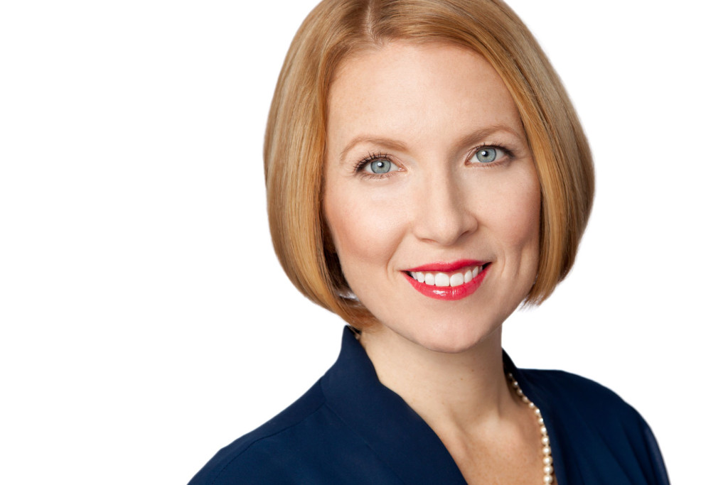 Headshot of blonde woman with blue eyes on white background using her Go-To expression.